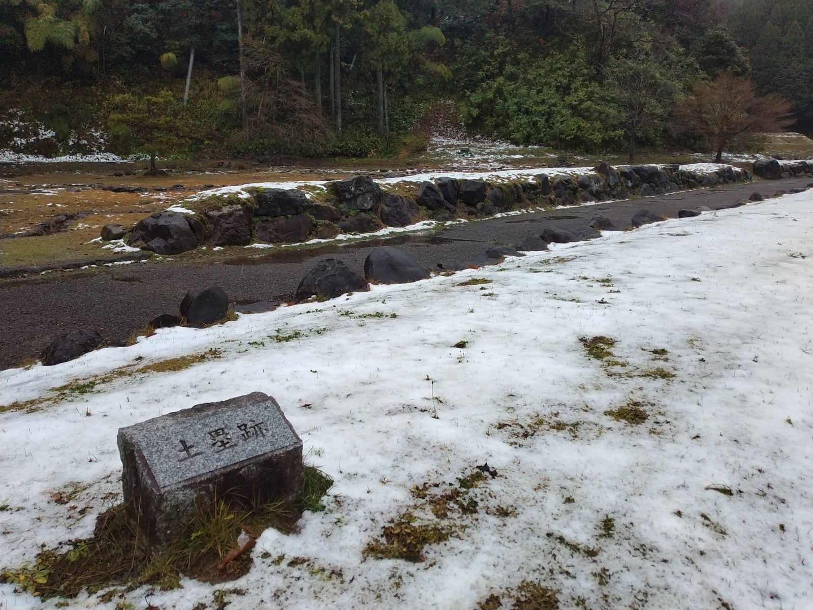 「土塁跡」の標柱。雪の下に、四百五十年前の盛り土がある