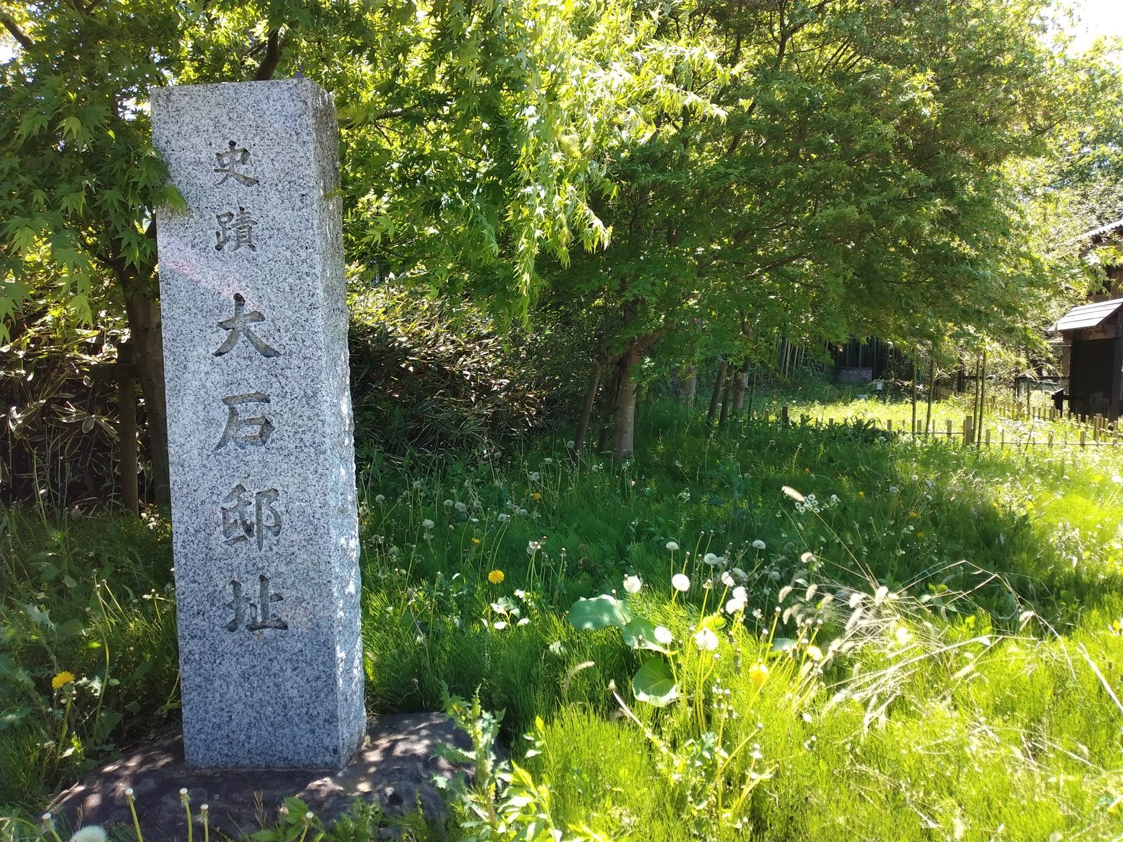 「史蹟 大石邸址」の石柱。原っぱの中にぽつりと立っている。