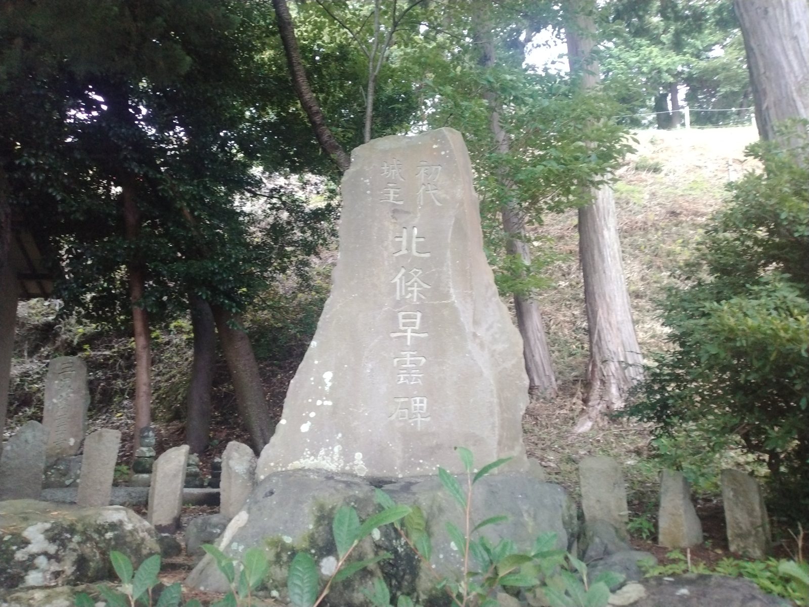 「初代城主 北條早雲碑」。まわりに小さな石仏が並んでいた