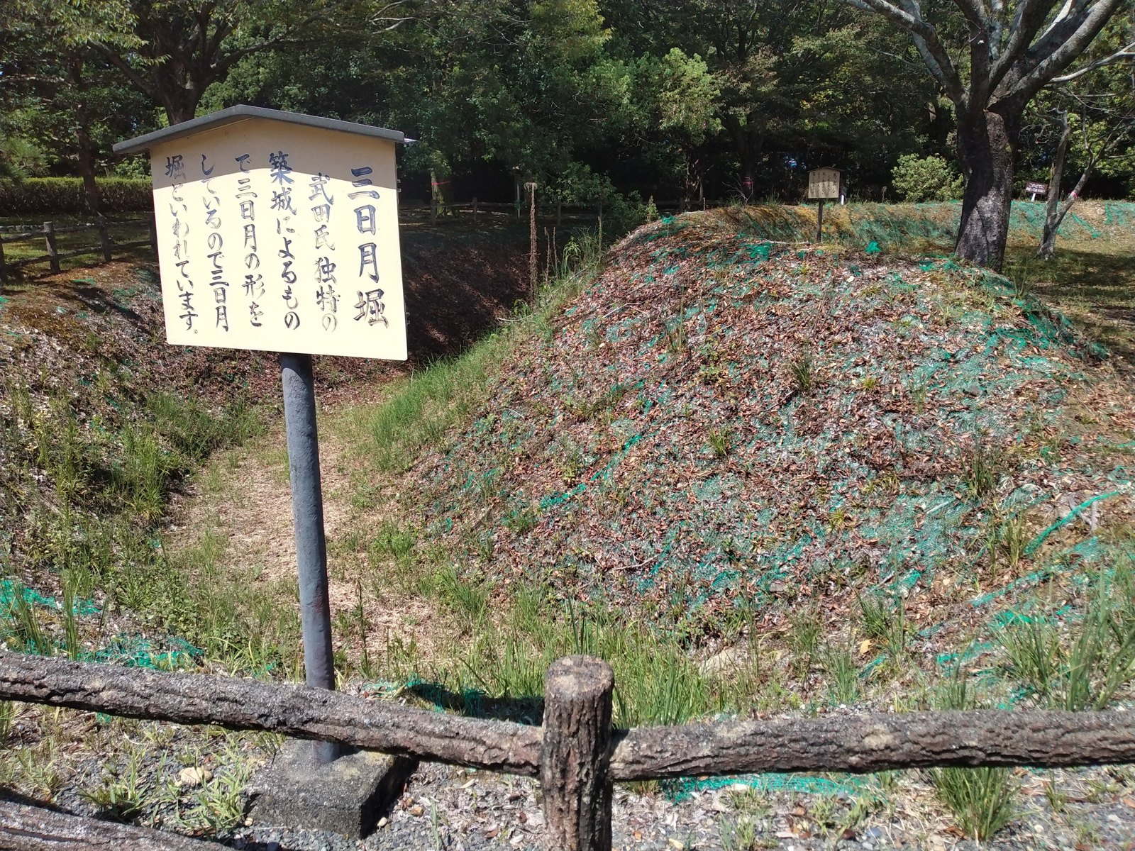 「三日月堀」の説明札。武田氏独特の築城によるもので、三日月の形をしていることからこの名がある