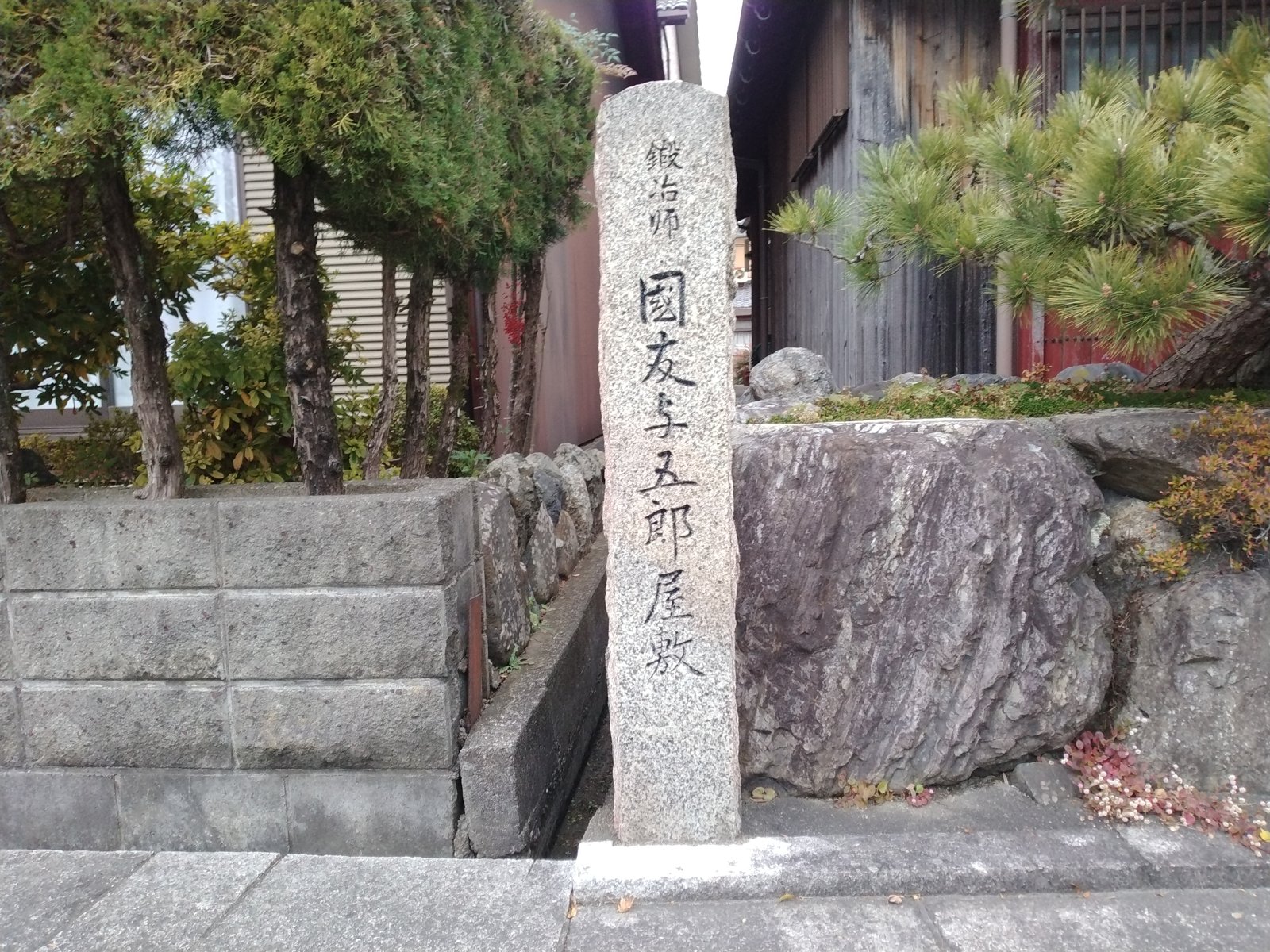「鍛冶師 國友与五郎屋敷」の標柱。民家の門先に立っている