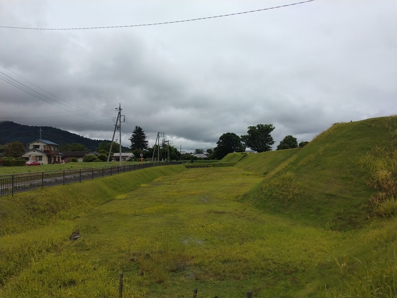 土塁と堀。背後にそびえるのは宝篋山。城はこの山の南西裾に築かれた