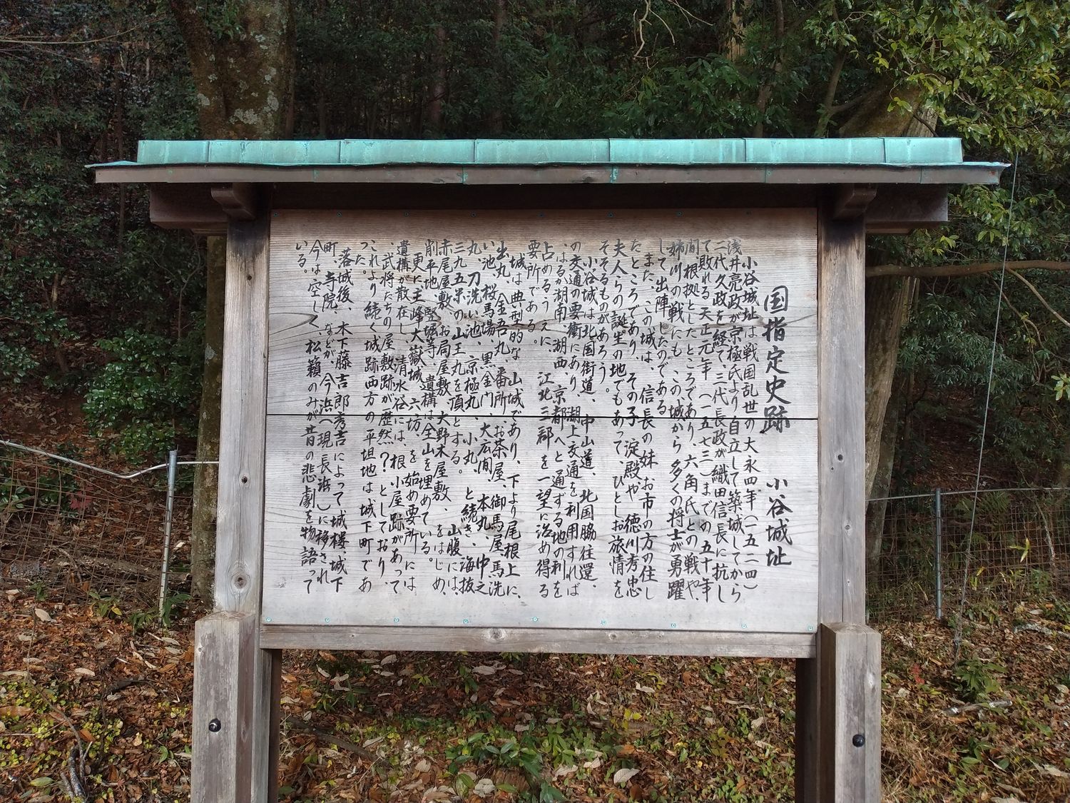 「国指定史跡 小谷城址」の案内板。手書きの文字がびっしりと埋めている。