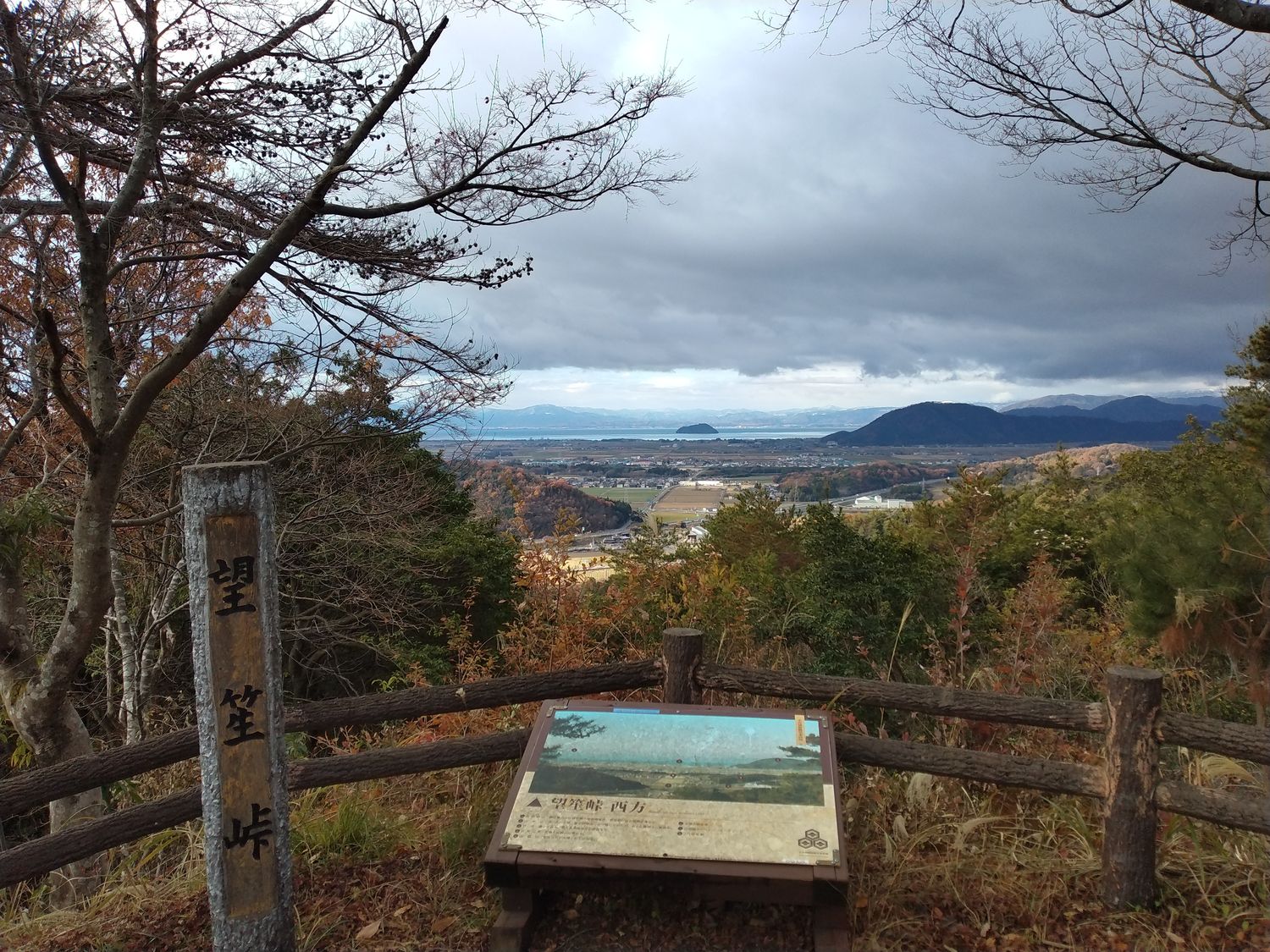 望笠峠の展望所から。眼下に湖北平野が開け、正面に虎御前山、その先に琵琶湖がかすんで見える。曇り空の初冬だった。