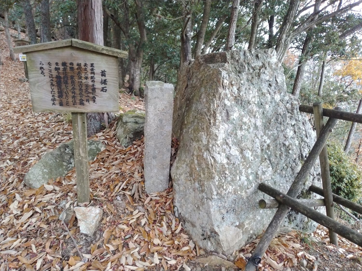 首据石。説明板の左端には「スズメバチ注意」の札が貼られていた。