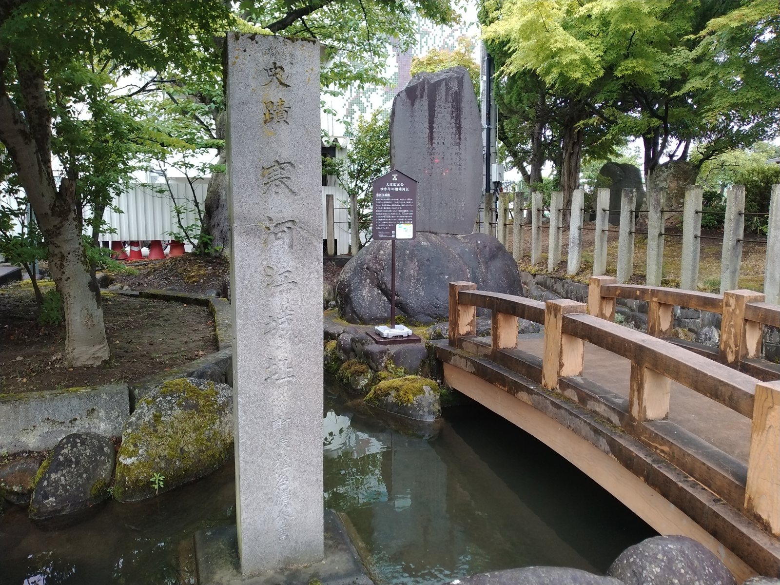 「史蹟 寒河江城址」の標柱。足もとには水をたたえた堀跡が残る