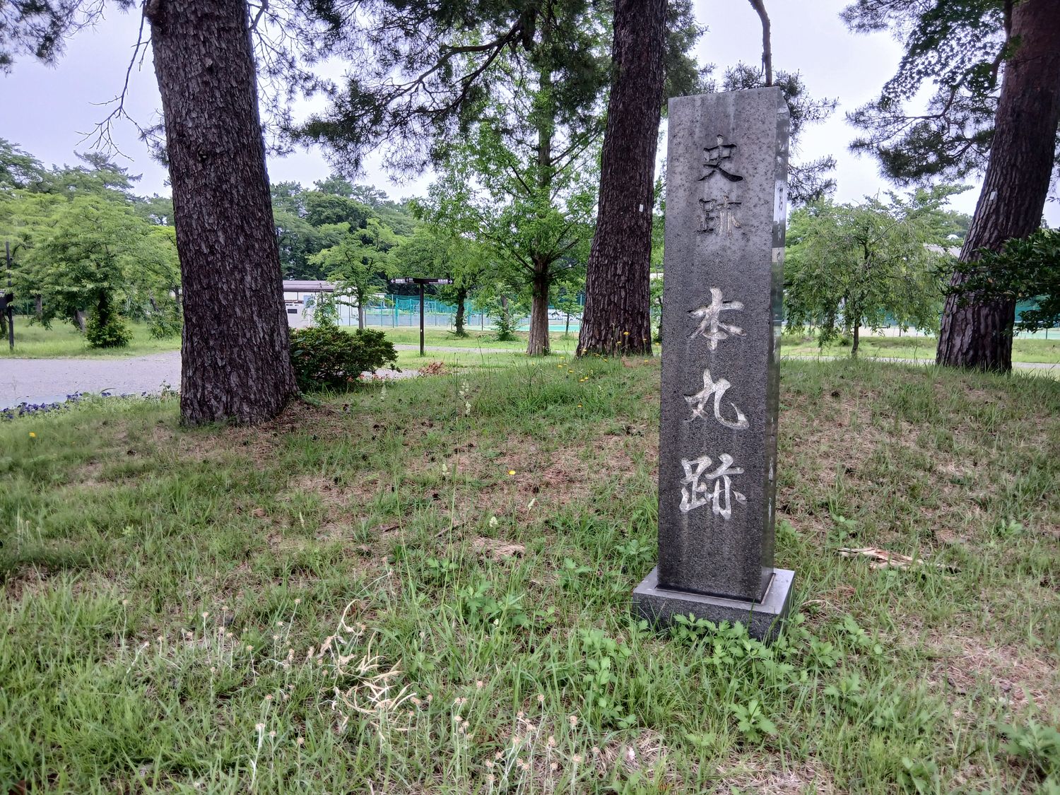 「史跡 本丸跡」の石柱。本丸内郭は東西二百十五メートル、南北二百二十八メートルあった。