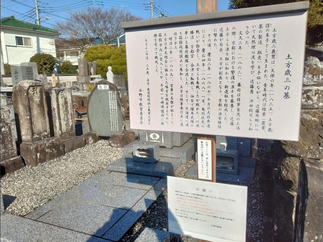 土方歳三の墓の前に立つ日野市教育委員会の説明板。