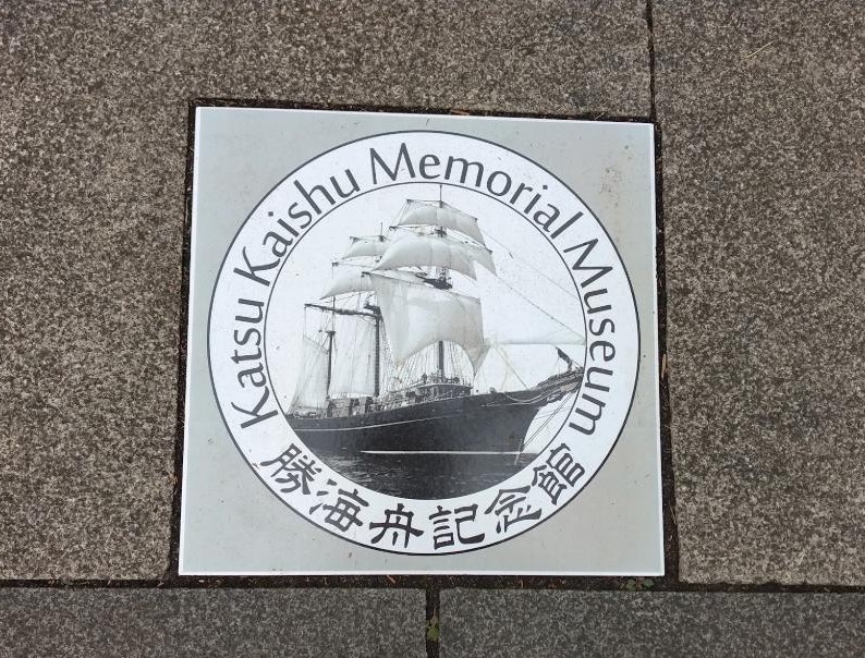 記念館の前の歩道に埋め込まれたプレート。帆船は、海舟が艦長格として太平洋を渡った咸臨丸を思わせます。