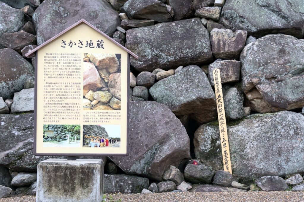 天守台北面の「さかさ地蔵」の説明板。右の卒塔婆には、城跡に眠る諸霊の供養の文字があります
