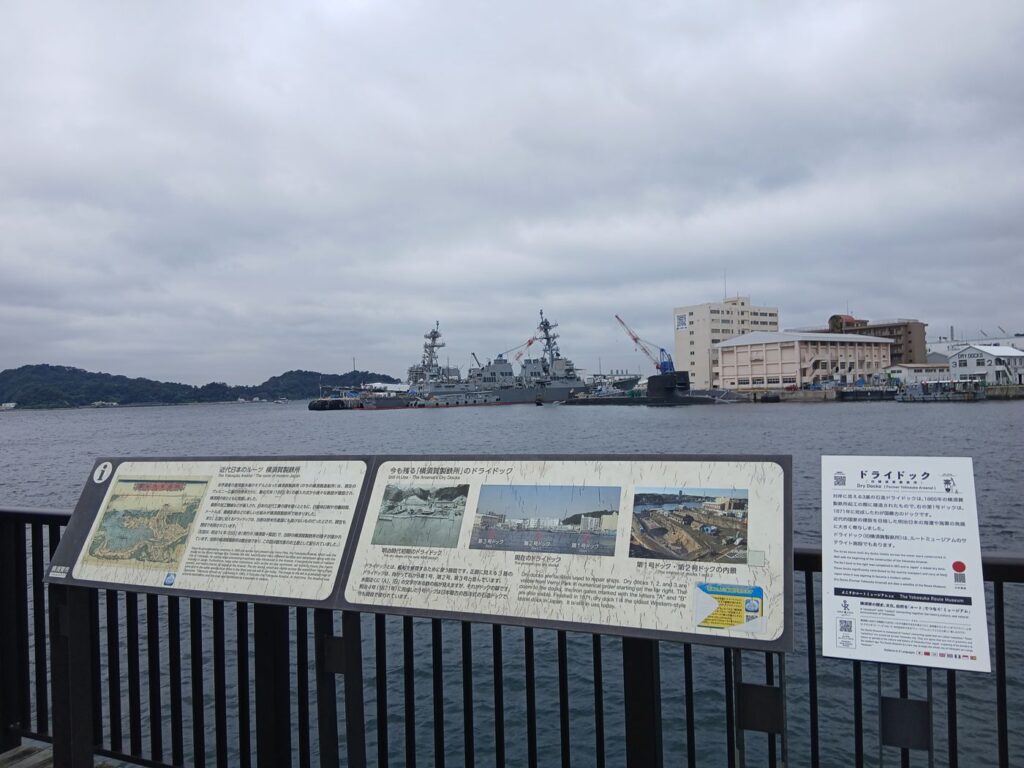 海沿いの柵に並ぶ解説板。対岸は米海軍横須賀基地